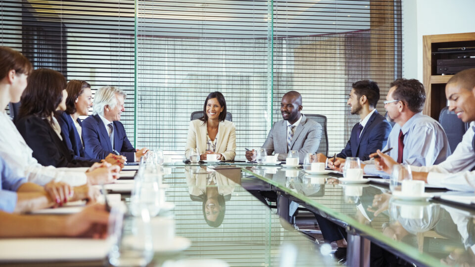 Business people having meeting in in conference room, smiling and discussing